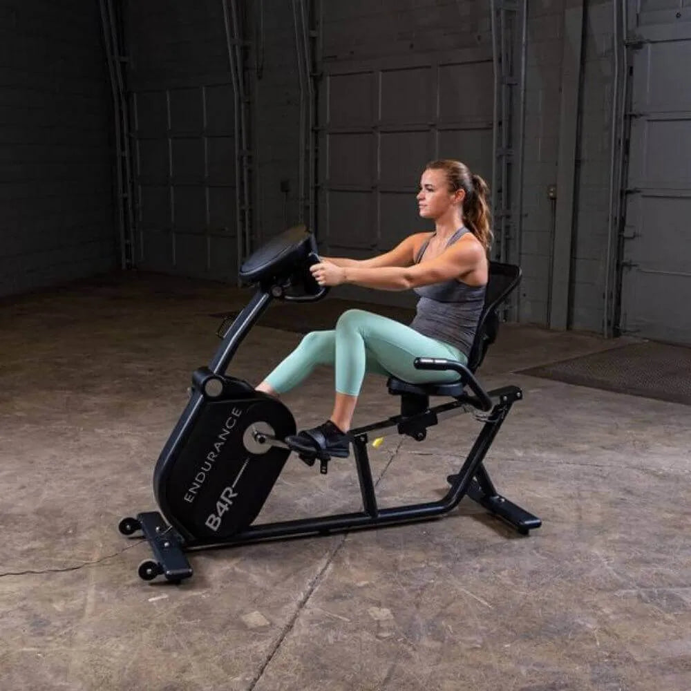 Body-Solid Endurance Recumbent Bike B4RB - woman using the machine and hands on the  handle