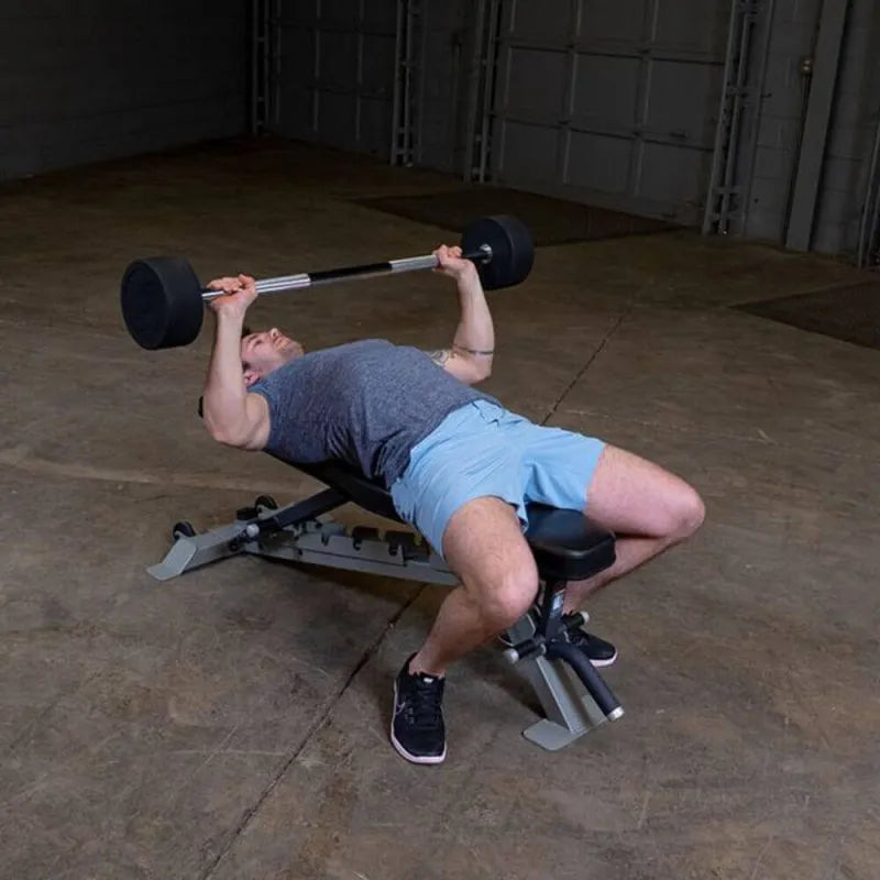 Body-Solid Fixed Straight Bars - Man lying on a bench while holding a barbell