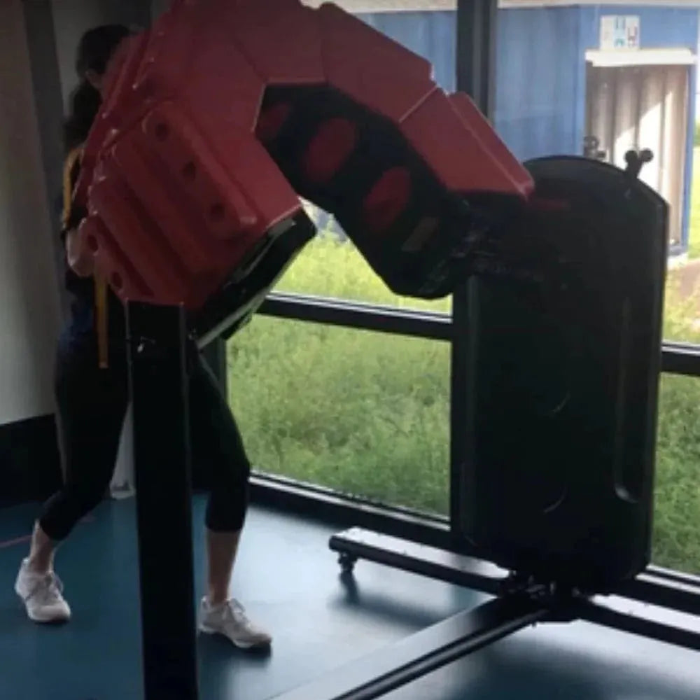 Marpo Tire Flip Machine - a woman using machine beside glass window with grass outside