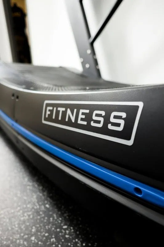 Vortex Strength CVX2500 Curved Treadmill - Close picture of the word "fitness" located at side of the running belt