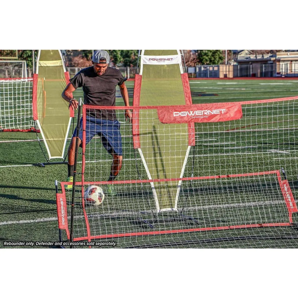 A boy playing soccer is using Powernet Fast Pass Rebounder Soccer Trainer 6x4 FT 1126
