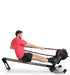 Ropeflex RX3200 ADDAX Rowing Rope Trainer - A man with stretched legs is sitting on a gym machine while pulling a rope