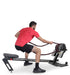 Ropeflex RX3200 ADDAX Rowing Rope Trainer - A man facing away from the camera while in a squat position is pulling a rope from a gym machine