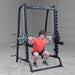 Body-Solid Series 7 Smith Machine - Man squatting while lifting weights