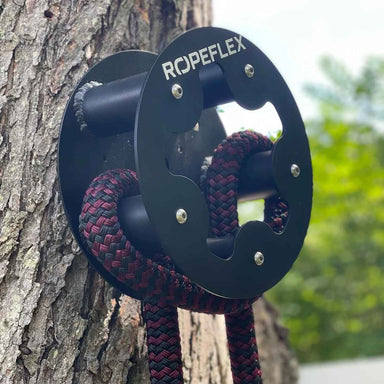 RopeFlex RX505 Hydra Friction Rope Training Drum - A thick rope attached to a gym equipment is hanging on a tree