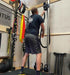 RopeFlex RX505 Hydra Friction Rope Training Drum - A man in an indoor facility is pulling a rope from a hanging gym equipment