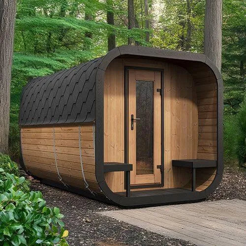 SaunaLife Model CL12GCP Cube-Series Outdoor Home Sauna Suite Kit, Up to 8 Persons - Set up in a forest with tall trees and green leaves