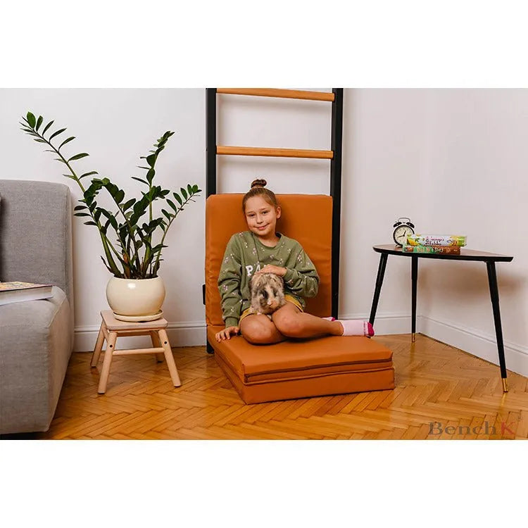 BenchK Gymnastics Mat - Girl sitting on top of brown folded mat 