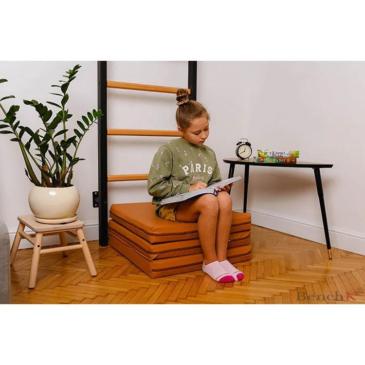BenchK Gymnastics Mat - A girl studying while sitting on brown mat