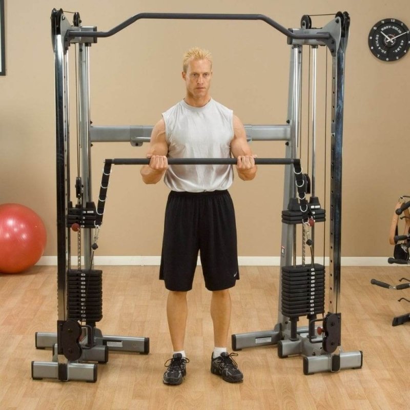 Body-Solid Bar Attachment GDCCBAR - Man holding bar attachment with yoga ball at the background