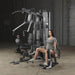 Body-Solid Bi-Angular Multi-Stack Gym G10B - Female model in gray shirt sitting side view