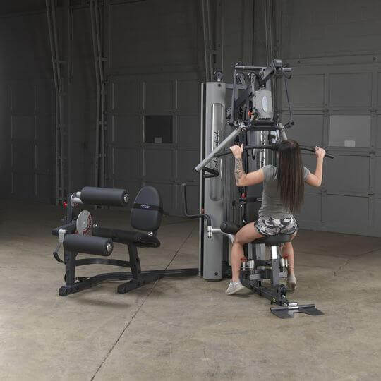 Body-Solid Bi-Angular Multi-Stack Gym G10B -  Female model sitting in front of multi stack gym doing arm workout