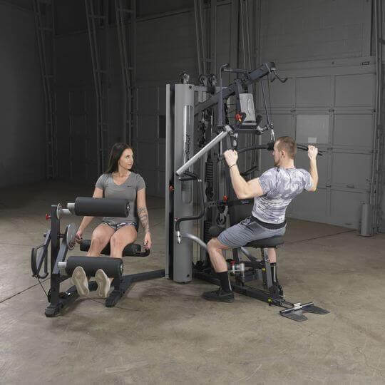 Body-Solid Bi-Angular Multi-Stack Gym G10B - Male and female model both sitting on two benches working out