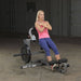 Body-Solid Cam Series Ab & Back Machine GCAB360 - Woman in pink tank top doing vertical sit ups