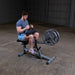 Body-Solid Commercial Seated Calf Raise GSCR349 - man sitting while holiding the cushioned handle