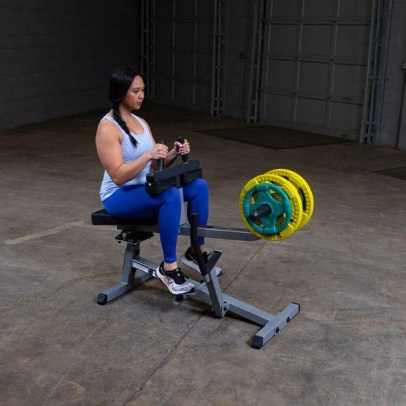 Body-Solid Commercial Seated Calf Raise GSCR349 - Woman sitting on the actual product with yellow and green plates