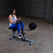 Body-Solid Commercial Seated Calf Raise GSCR349 - Woman workout and holding the cushioned holder