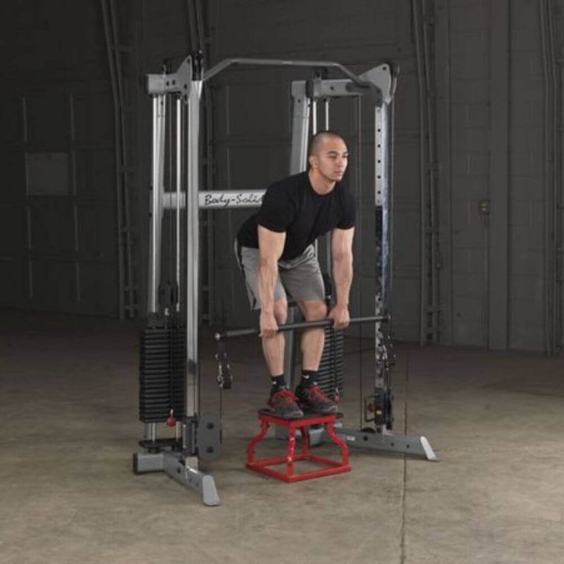 Body-Solid Compact Functional Training Center GDCC210 Man standing on a training chair while holding a bar