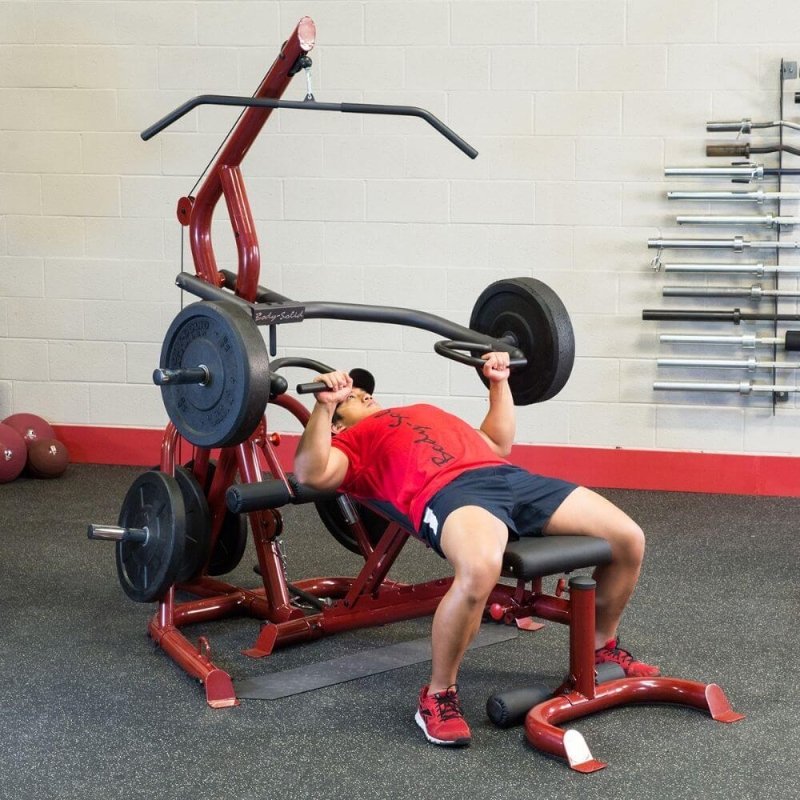 Body-Solid Corner Leverage Gym GLGS100 - Man lying on the bench to lift weights holding press arm 