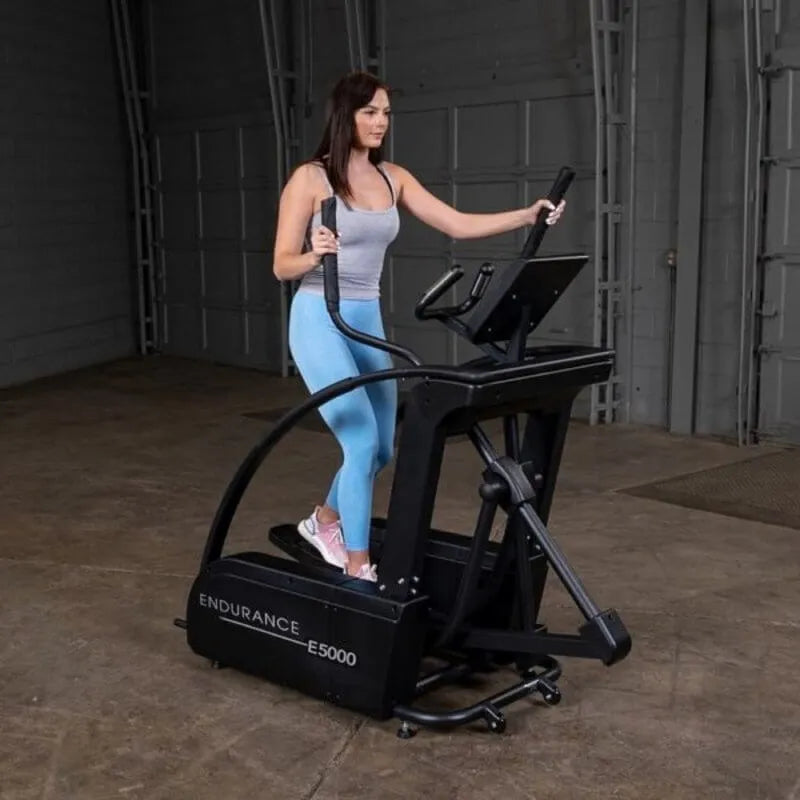 Body-Solid Endurance Center Drive Elliptical E5000 - side view photo of woman using the equipment