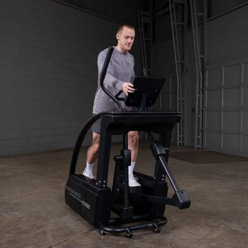 Body-Solid Endurance Center Drive Elliptical E5000 - Man on the equipment and hands on console