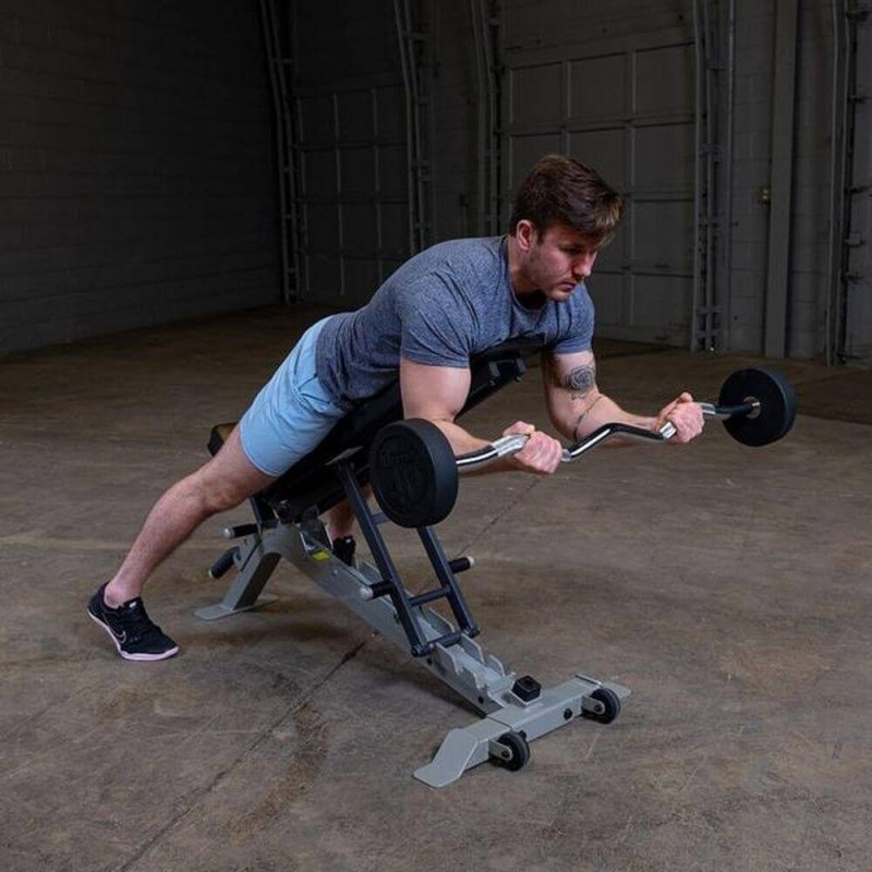 Body-Solid Fixed Curl Bar Sets - Man lying towards the product and working out muscles