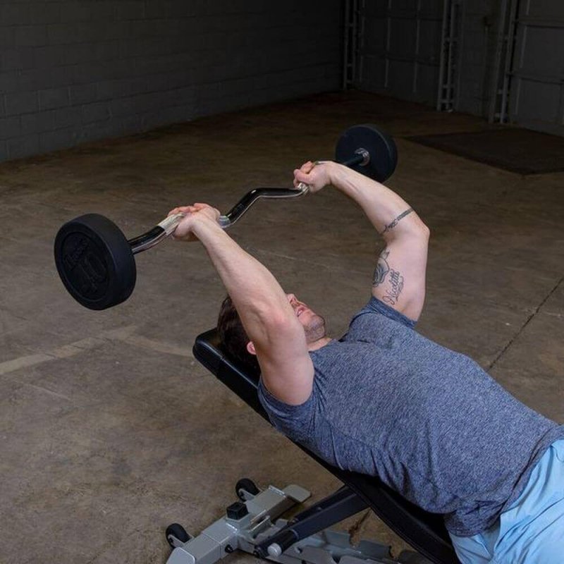 Body-Solid Fixed Curl Bar Sets - Man lying down holding rod and lifting weights