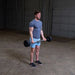 Body-Solid Fixed Straight Bars - Man standing while lifting the barbell