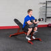 Body-Solid Flat Incline Decline Bench GFID100 - Man on training with actual product - preacher curl dumbbells