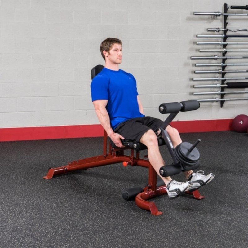 Body-Solid Flat Incline Decline Bench GFID100 - man sitting on bench and weights above leg cushioned 