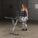 Body-Solid Flat Incline Decline Bench GFID31 - woman holding and lifting other side of the product 