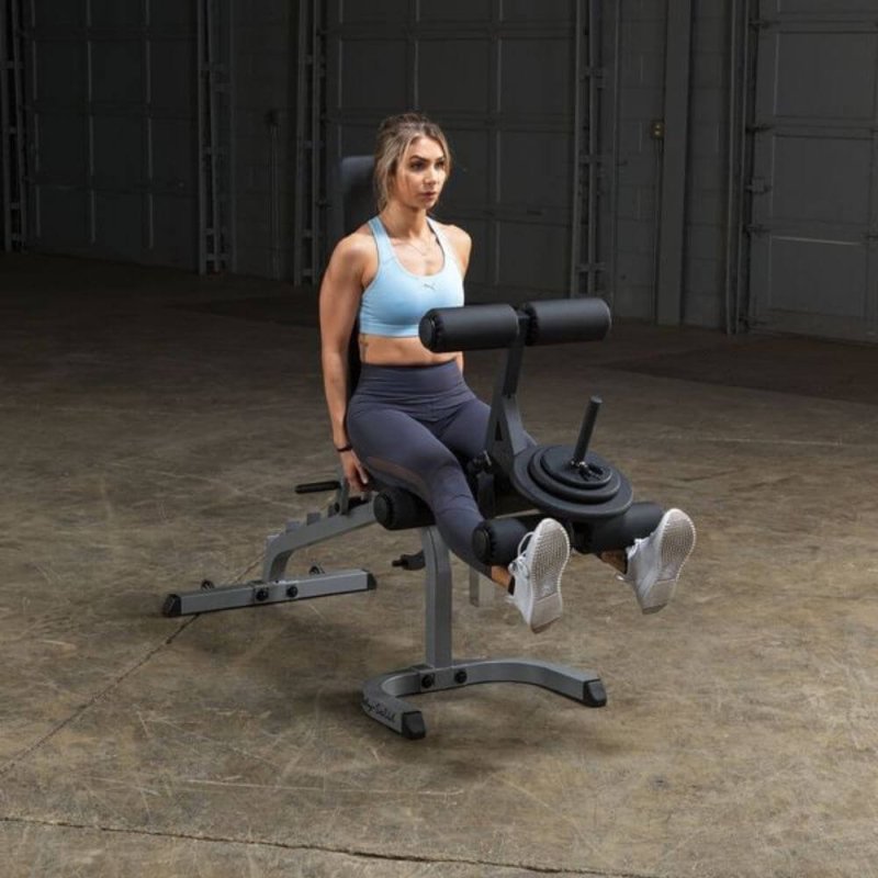 Body-Solid Flat Incline Decline Bench GFID31 - woman sitting working out with leg raise on cushioned support with weight plate