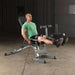 Body-Solid Flat Incline Decline Bench GFID71 - Man in green shirt sitting on bench lifting weights with his legs