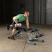 Body-Solid Flat Incline Decline Bench GFID71 - Man in green shirt holding silver dumbbell