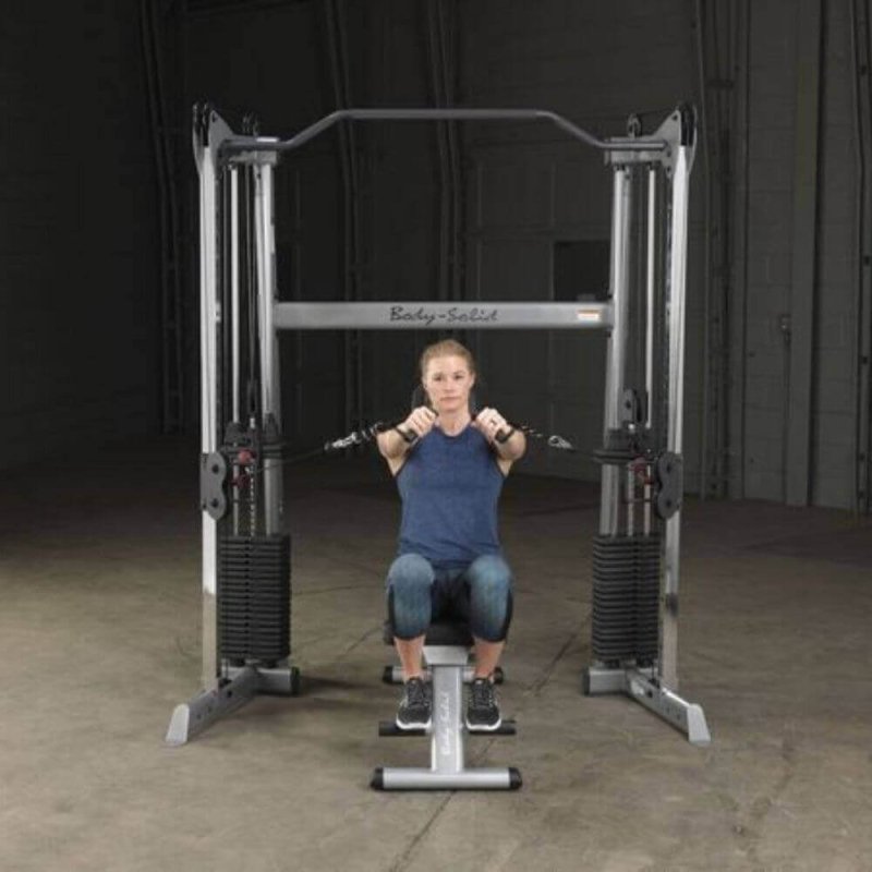 Body-Solid Functional Training Center GDCC200 - woman in front view holding 2 handles while sitting on bench