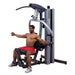 Body-Solid Fusion 500 Modular Single Stack Gym F500 - man on cushioned seat to work out