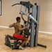 Body-Solid Fusion 600 Personal Trainer F600 man sitting on opposite position