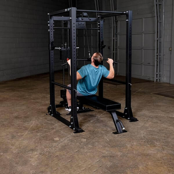 Body-Solid GPR400 Power Rack - Man sitting on bench while holding lat bar for shoulder press exercise