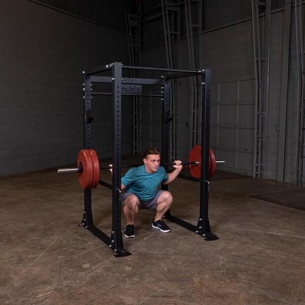 Body-Solid GPR400 Power Rack - Man squat position while holding the barbell on the actual product