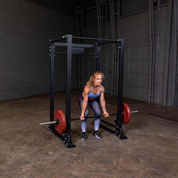 Body-Solid GPR400 Power Rack - Woman working out holding the barbel rod with one plates on opposite sides in color red