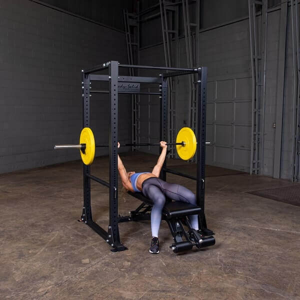 Body-Solid GPR400 Power Rack - woman laying on bench holding the barbell with one plates on opposite sides in color yellow