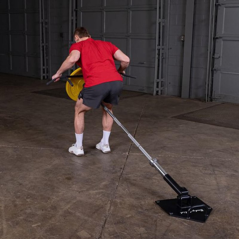 Body-Solid Home Plate T-Bar Row Landmine TBR50 - Man working out with rod placed between his legs holding it with heavy plate