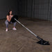 Body-Solid Home Plate T-Bar Row Landmine TBR50 - Woman on squat position holding the rod with weight plate