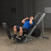 Body-Solid Leg Press & Hack Squat GLPH1100 - man working out doing. squats on the product