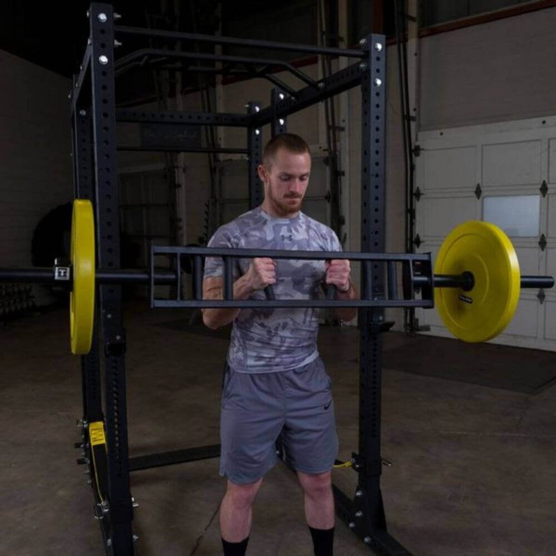 Body-Solid Multi Grip Olympic Bar OMG86 -  Man standing and holding the bar with weight plate in yellow color