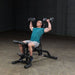 Body-Solid Olympic Leverage Exercise Bench with Leg Developer FID46 - Man sitting straight doing shoulder press