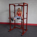 Body-Solid Power Rack Dip Attachment DR100 - Woman with leg raise exercise