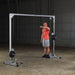 Body-Solid Powerline Cable Crossover PCCO90X - man exercising next to a metal bar