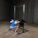 Body-Solid Powerline Half Rack PPR500 - man doing bench press next to a metal bar