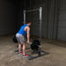 Body-Solid Powerline Half Rack PPR500 - man lifting weights beside the metal bar